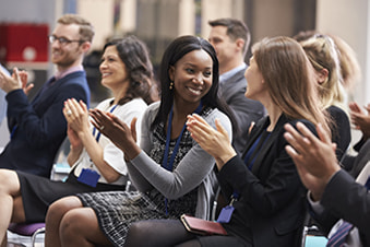 Colleagues applaud after a conference presentation